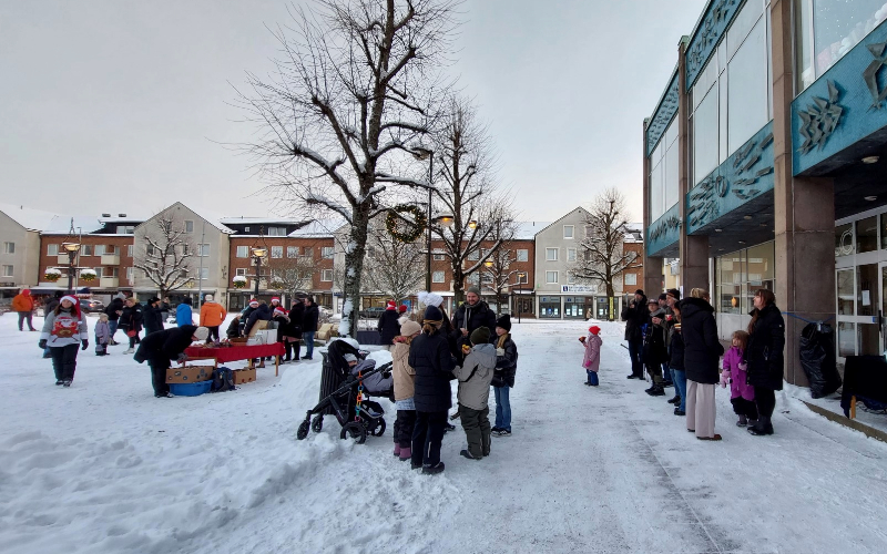 Ett tjugotal personer står på torget i Degerfors och dricker glögg och äter lussebullar.