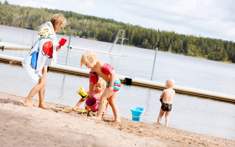 Badstranden i Svartå med barn som leker i sanden